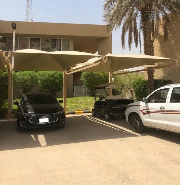 "مظلات سيارات خارجية بتصميم هرمي متين لحماية المركبات من الشمس والأمطار في جدة، تركيب عملي وعصري لمواقف السيارات."